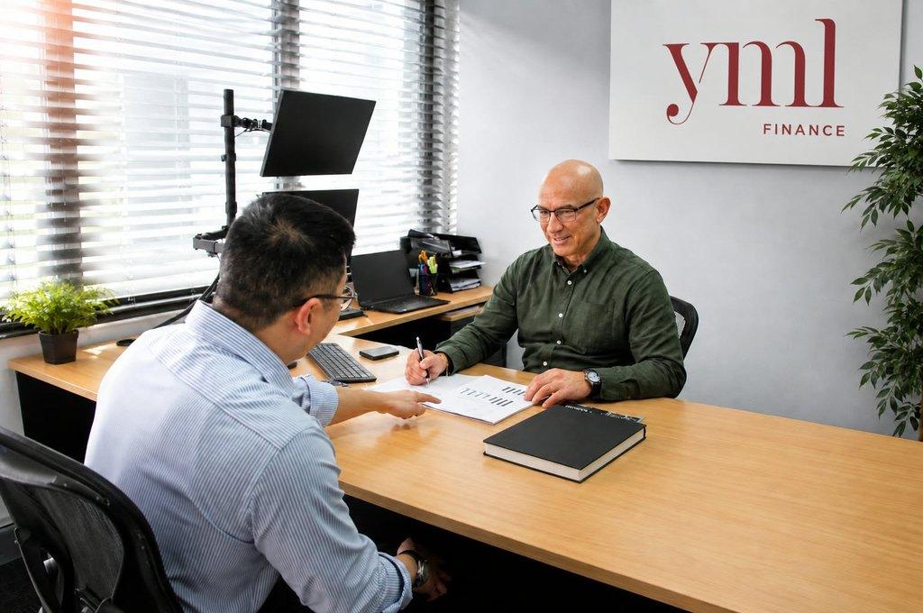 Jay Perron with a client at the YML Finance office
